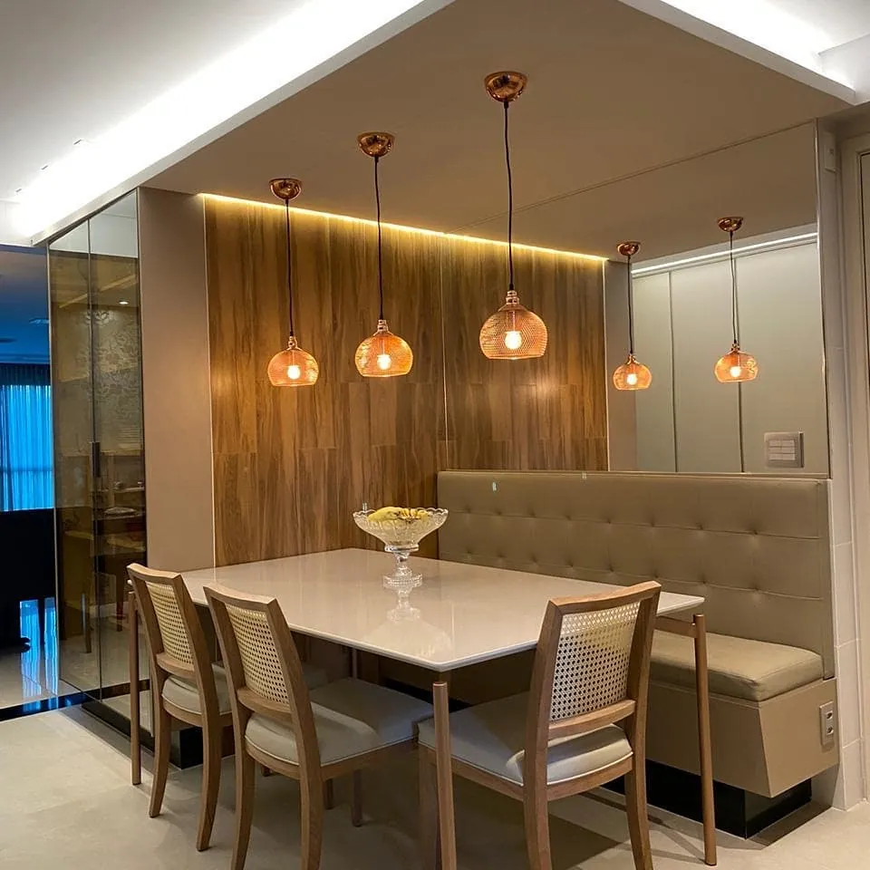 Sala de jantar com painel em madeira e banco estofado